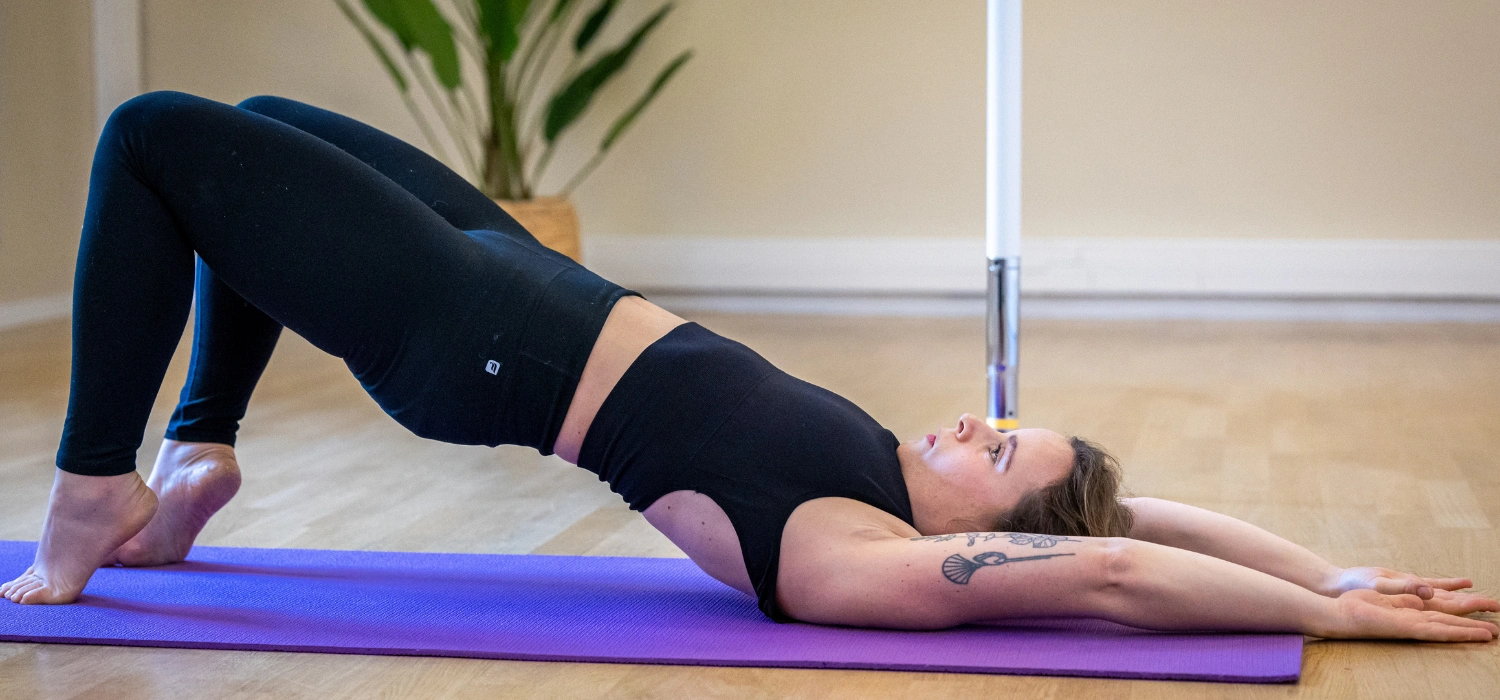 Astrid en posture de pont sur tapis pendant un cours de Pilates au Momentum Studio à Strasbourg.