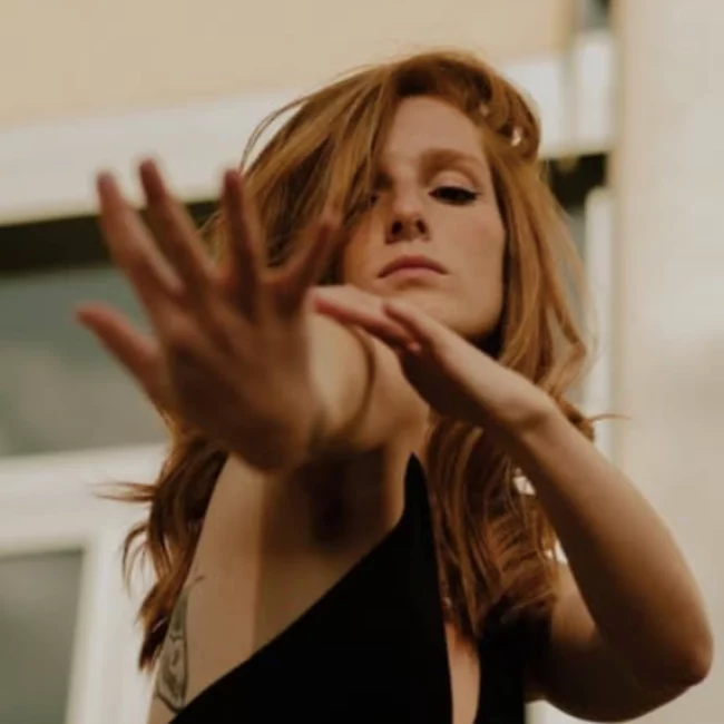 Charlène, danseuse de lyrical flow, bras tendu dans un geste expressif, symbolisant la connexion entre émotion et mouvement.