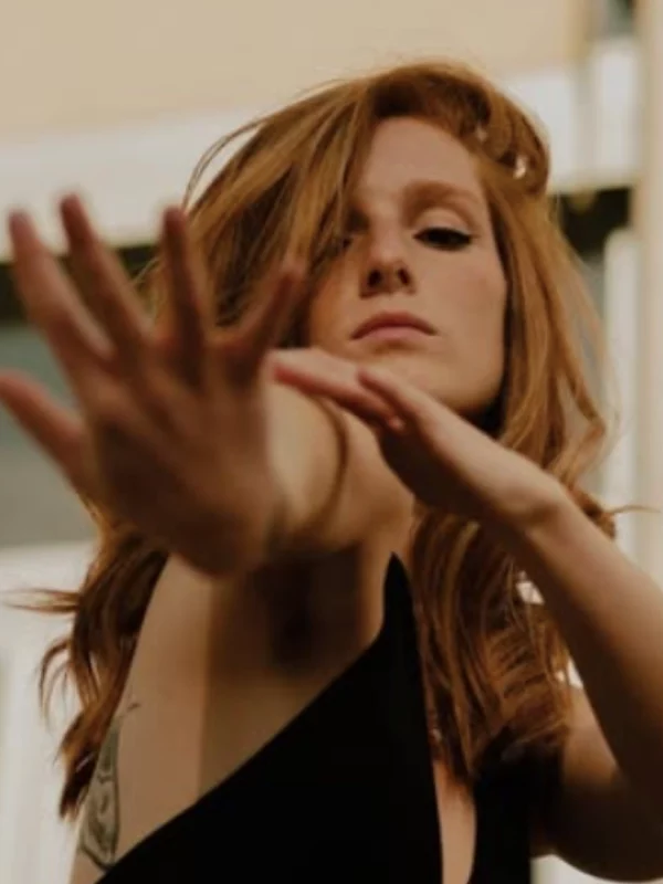 Charlène, danseuse de lyrical flow, bras tendu dans un geste expressif, symbolisant la connexion entre émotion et mouvement.